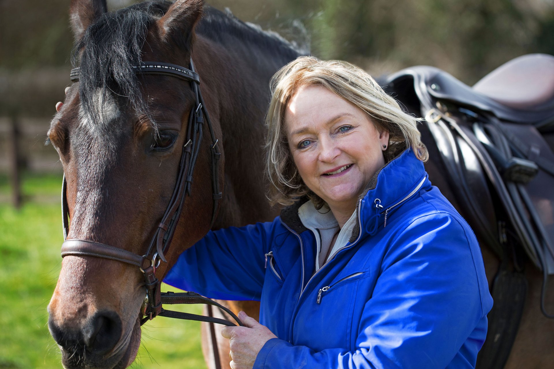 Portrait einer Reitstallbesitzerin mit einem ihrer Pferde