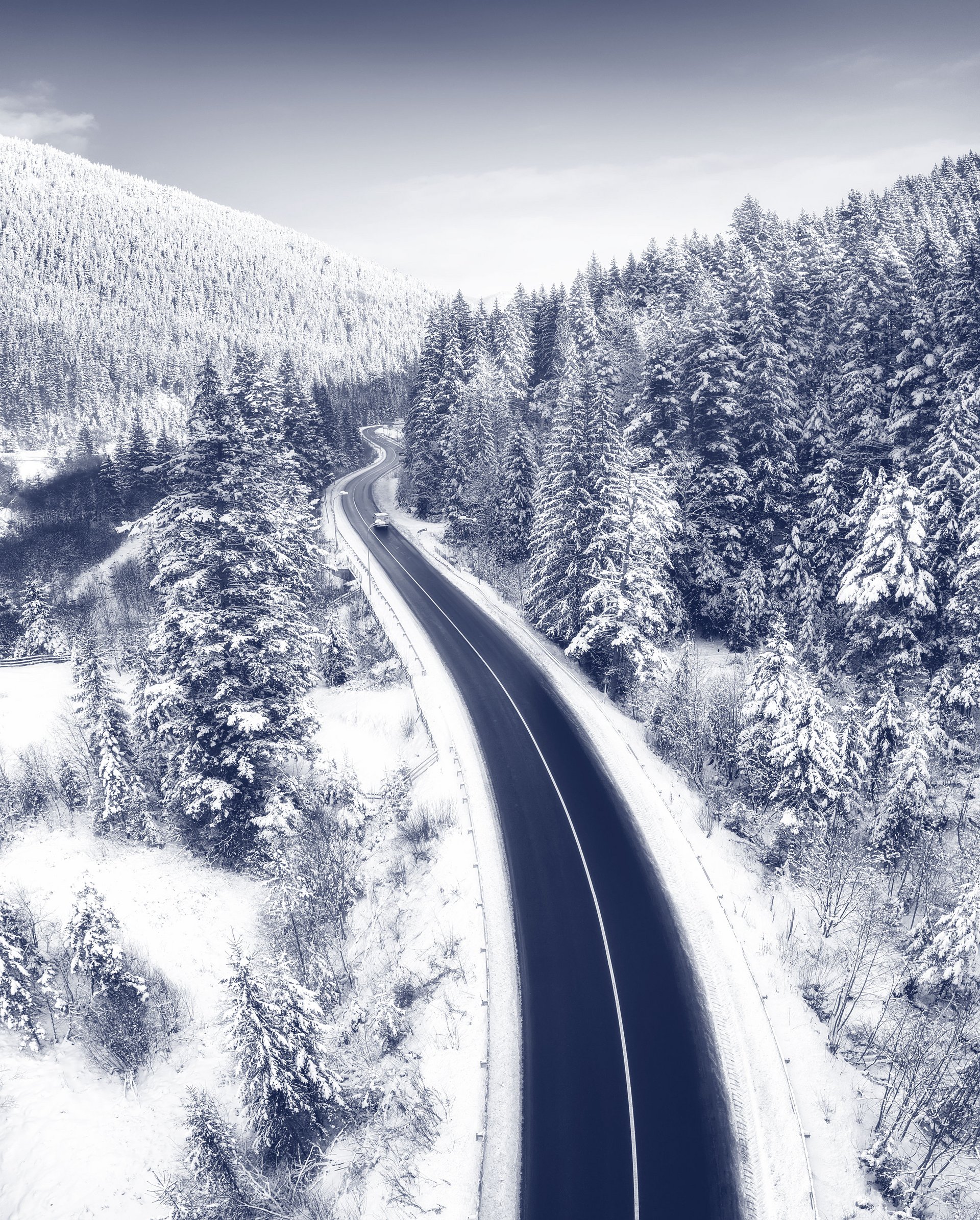 Straße führt durch Winterlandschaft.