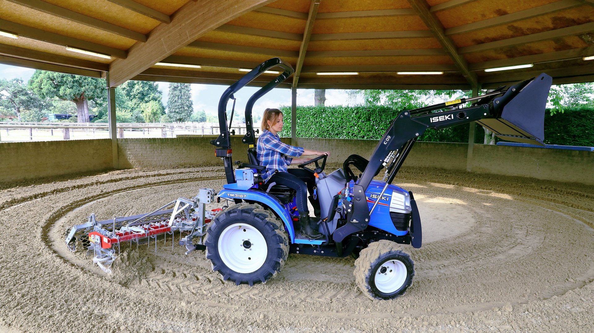 Traktor mit Bodenfräse im Einsatz im Laufstall.